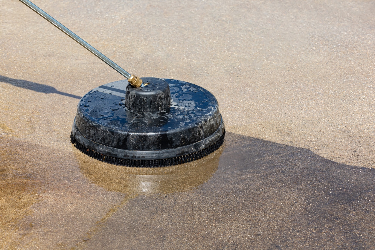 Pressure washing and cleaning dirty concrete driveway Home cleaning maintenance and household chores concept | Ultra Clean, LLC technician in plano power washing